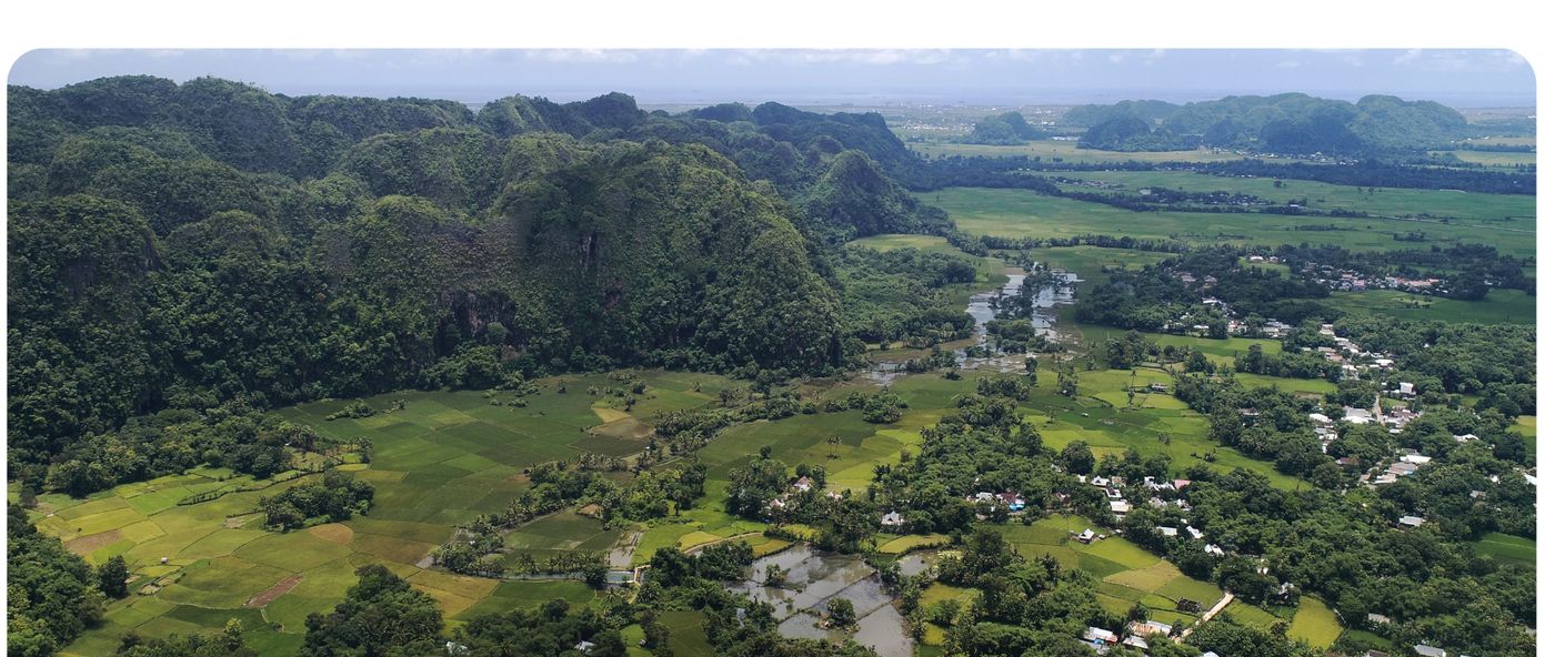 Aerial view of a restored valley landscape with rice fields, villages and forested karst hills